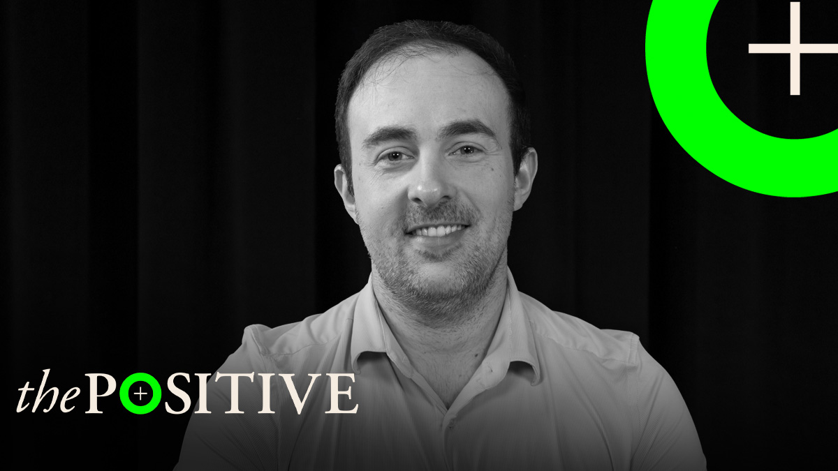 Retrato del hematólogo Adrián Mosquera con el logotipo de The Positive, de THE OBJECTIVE